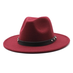 Close-up of wine red wool fedora hat featuring a black leather band with silver studs