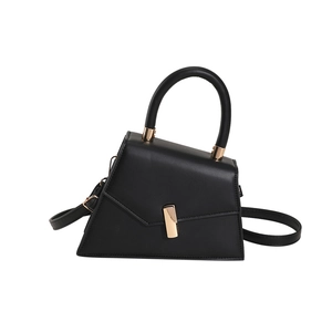 Minimalist black irregular leather handbag with golden hardware and adjustable strap