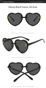 Detail view of heart-shaped sunglasses featuring gold bee motifs on black frames