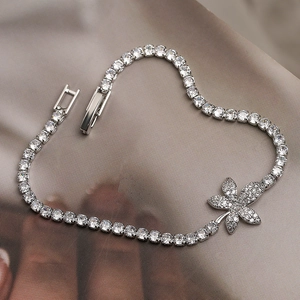 Detail of silver leaf zircon bracelet showing intricate stones on satin background