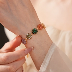 Detailed view of colorful zircon flower bracelet in 18K gold plating on model wrist