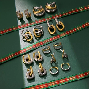 Détail de boucles d'oreilles bicolores or et argent sur des rubans festifs à carreaux