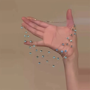 Collier multi-rangs doré avec pierres gouttes bleues au design luxueux et minimaliste