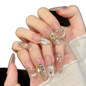 Faux ongles dégradé rose nude avec effet œil de chat et cristaux dorés luxueux