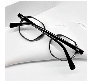 Detail of black geometric hexagonal glasses frame with white leather pouch accessory