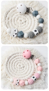 Detail of handmade crochet fox pacifier clips with silicone beads and wooden accents