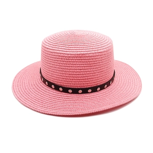 Détail du tissage du chapeau de paille rose et ruban noir avec rivets argentés