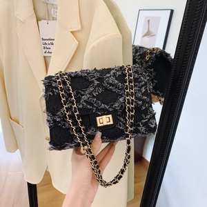 Elegant black denim chain flap bag with gold hardware and stylish twist-lock closure