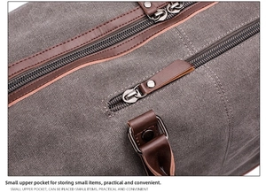 Close-up detail of grey canvas travel bag showing top zipper pocket and leather accents
