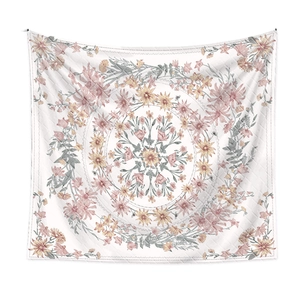 Detailed view of square fabric tapestry with pink and yellow floral mandala patterns