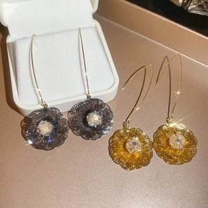 Vue macro de boucles d'oreilles fleurs en plaqué or 18K avec zircons scintillants