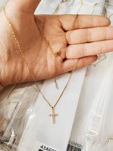 Detail of 18K gold plated cross necklace with micro-paved CZ zircons and lobster clasp