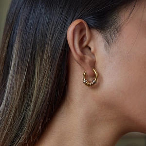 Minimalistische goldene und silberne Creolen mit stapelbarem Ringdesign an einem Modell