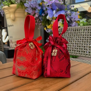 Close-up of red Chinese wedding candy bags with gold brocade and Double Happiness charms