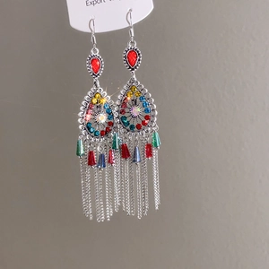 Detailed shot of ethnic silver fish earrings with colorful crystals and long tassels