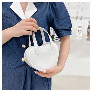 Detail shot of heart-shaped white mini jelly handbag with golden zipper and D-ring buckle