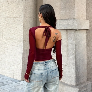 Detail of burgundy backless long sleeve top with elegant knot tie and slim fit design
