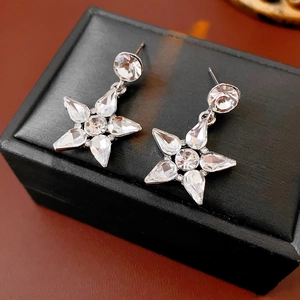 Macro shot of silver star drop earrings with sparkling cubic zirconia on a black gift box