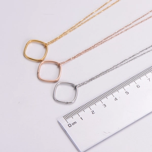 Detailed view of square geometric pendant necklaces in gold, rose gold and silver