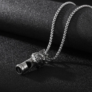 Gros plan du pendentif sifflet tête de loup argenté avec chaîne box en acier