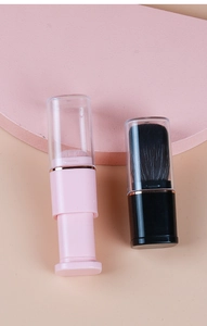 Detail of pink and black retractable makeup brushes with gold rings and clear caps