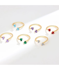 Macro detail of six birthstone heart rings with gold woven texture and zircon inlay