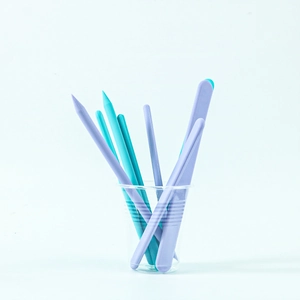 DIY silicone resin mixing tools set with purple and blue spatulas in a clear cup