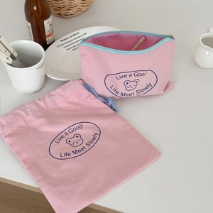 Pink canvas drawstring bag and zipper pouch set featuring a cute bear logo and quote