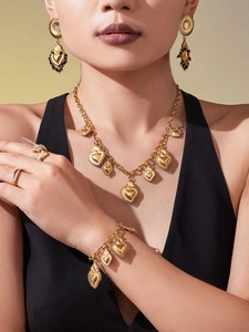 Parure de bijoux dorés 18 carats avec pendentifs cœur et bague serpent portés par un mannequin