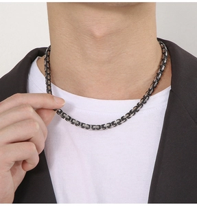 Male model wearing a 5mm silver and black Byzantine steel chain necklace on white tee