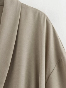 Macro view of taupe linen-blend fabric texture and stitching on the collar and shoulder