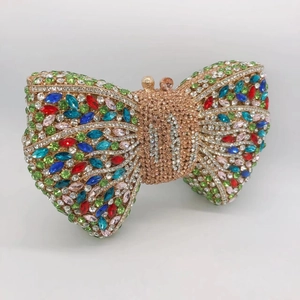 Macro view of crystal bow clutch bag with colorful rhinestones on a gold frame