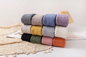 Pile of colorful plush coral fleece over-knee socks in various soft winter tones