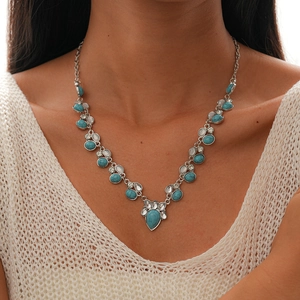 Close-up of Bohemian turquoise moon and star pendant necklace on a female model