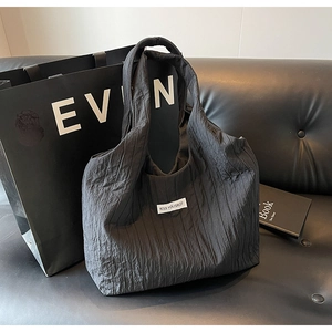 Detail der schwarzen Hobo-Tasche mit großer Kapazität, Faltenstruktur und Logo-Etikett
