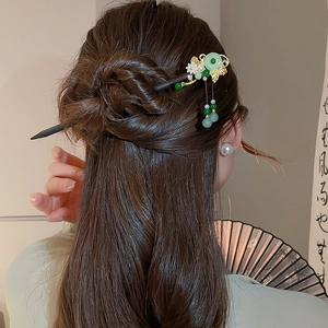 Detail of traditional Chinese hair pin with butterfly tassel on a wooden hair stick
