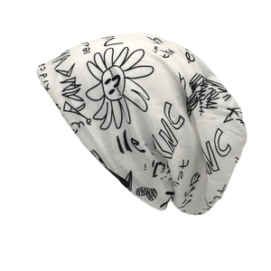 White slouchy beanie with black graffiti prints and sun pattern for street fashion
