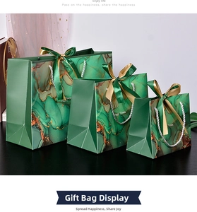Detail of three sizes marble pattern gift bags with gold ribbons and Happy Times text