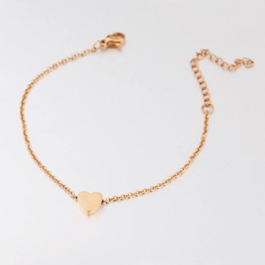 Golden stainless steel heart pendant anklet with adjustable lobster clasp on white background