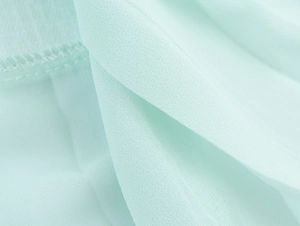 Macro shot of mint green tweed fabric texture with delicate stitching details