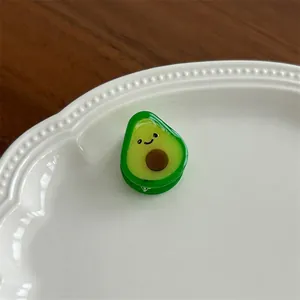 Close-up of a cute cartoon avocado hair clip on a white ceramic shell plate