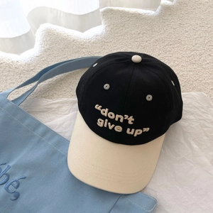 Detalle del bordado don't give up en una gorra de béisbol de algodón bicolor