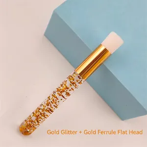 Detail view of portable eyelash cleaning brush with gold sequins and flat white bristles