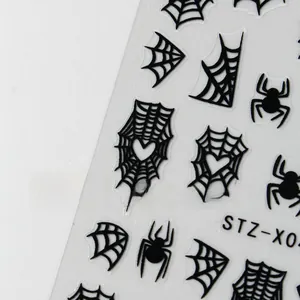 Detailed view of Halloween nail stickers featuring black spiders and heart spider webs