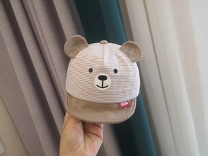 Detail of khaki striped baby baseball cap with cute bear ears and cotton texture