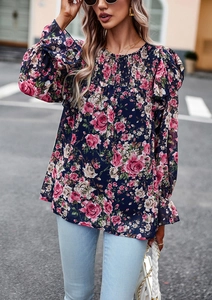 Detail of floral printed navy blouse with smocked bodice and ruffled long sleeves