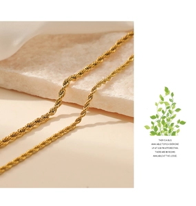 Detailed view of a golden twist rope chain necklace on a light stone with high shine