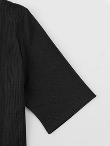 Macro shot of black seersucker texture showing the sleeve detail and fabric quality