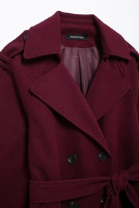 Gros plan d'un manteau en laine bordeaux avec col à revers et boutons à double boutonnage