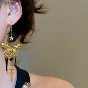 Détail de la boucle d'oreille vintage française avec lune, papillon et pampilles épée